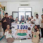 Tim Rene Turos Group dan santri Pesantren Almanar Azhari Depok memegang spanduk 1.600 Kado Buku